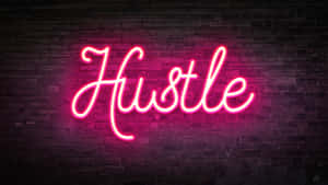 粉紅色霓虹燈牌，上面寫着 'Hustle'，掛在深色磚牆上。