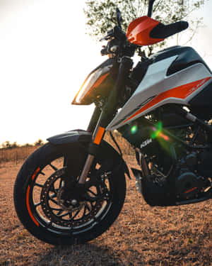 KTM Duke電單車在日落時停放在草地上，帶鏡頭眩光 — 機車 壁紙