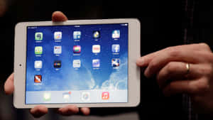 雙手拿著白色iPad，顯示星空背景上的應用程式圖標。