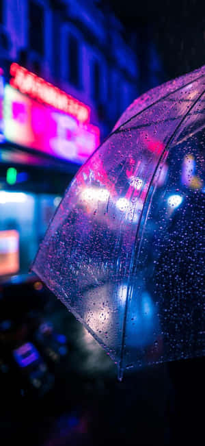 透明雨傘上的雨滴在夜晚城市霓虹燈下閃爍。