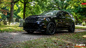 黑色Jeep Grand Cherokee SRT停泊在墓園中，伴有秋葉和墓碑。