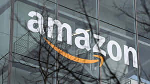 玻璃建築上的Amazon標誌，前面有光禿禿的樹枝。