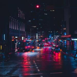 雨濕的夜晚城市街道，閃爍著霓虹燈光和倒影。
