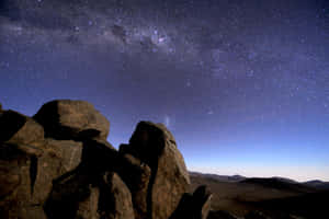 在可見銀河的星空夜空下的剪影岩石。 — 天空景觀 壁紙
