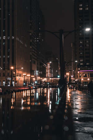 芝加哥城市街道夜景，濕漉漉的路面反射著霓虹燈光和高樓大廈。