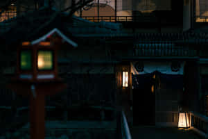 夜晚，一個發光的紅色燈籠矗立在傳統日本旅館前。