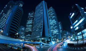 夜晚的城市景觀，發光的摩天大樓和流動的交通燈光。