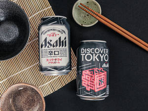 竹蓆上的兩罐Asahi啤酒罐，配陶瓷碗和筷子。 — 日本 壁紙