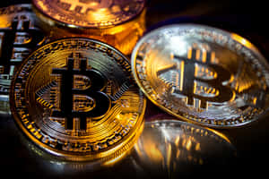 閃亮的金色和銀色比特幣硬幣在黑暗表面上反射光線。 — 比特幣 壁紙