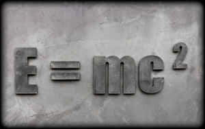 混凝土牆上凸起的金屬字母E=mc²公式。