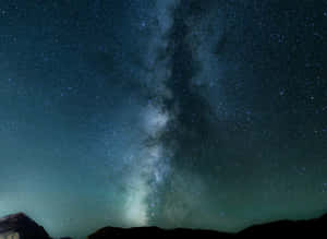 銀河系在繁星點點的夜空下，於山頂上方閃耀。