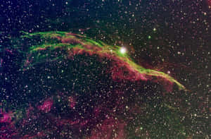 在深空中無數恆星之間發光的充滿活力的綠色和粉紅色星雲。
