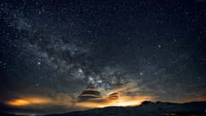 發光雲彩下星空中的雪山