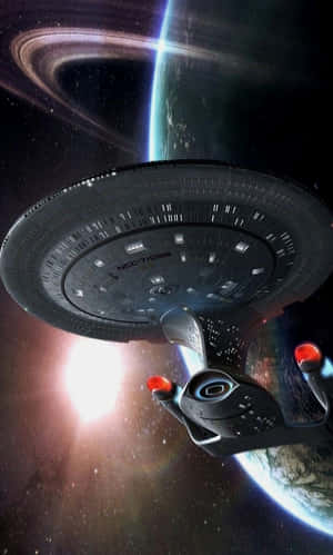 星艦企業號繞著一個帶環行星運行，背景有明亮的星爆。