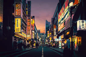 黃昏時霓虹燈照亮東京街道，有行人和發光招牌。 — 霓虹城市 壁紙