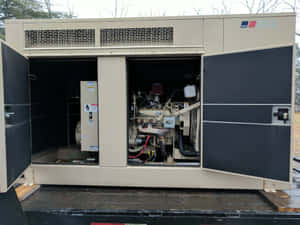 米色工業發電機，門打開顯示卡車車斗上的引擎。