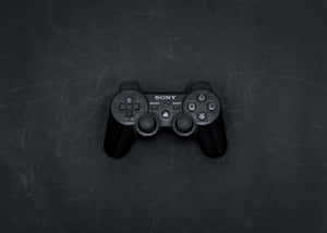 黑色Sony PlayStation 3手掣放在有刮痕的深灰色表面上。