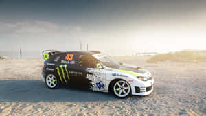 帶有Monster Energy品牌的Subaru拉力賽車，在日落時分停泊在沙灘上。