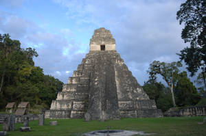 古代瑪雅金字塔被叢林和草地環繞，天空多雲
