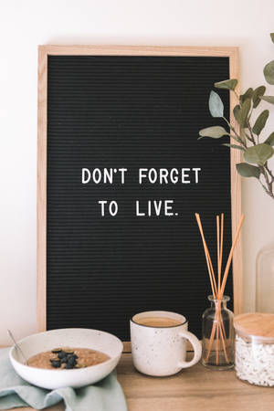 舒適的早餐擺設，有燕麥片馬克杯和寫著「Don't Forget to Live」的字母板
