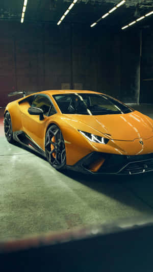 橙色林寶堅尼跑車在光線昏暗的車庫中，上方有燈光。