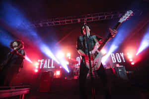 Fall Out Boy 樂隊在紅色和藍色燈光下現場表演。