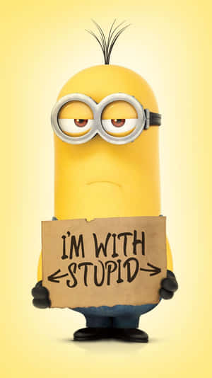一個黃色卡通Minion舉住一塊寫住「I'M WITH STUPID」嘅牌。 — 搞笑 壁紙