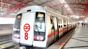 銀色地鐵列車帶有紅色標誌停在車站月台，乘客正在等候。