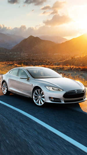 銀色Tesla Model S在金色日落時分在沙漠公路上飛馳。