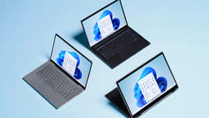 三部手提電腦在藍色背景上顯示 Windows 11 介面