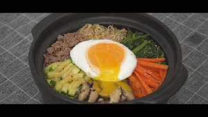 一個冒煙的石鍋韓國拌飯，上面放著一個流心蛋。 — 美食 壁紙