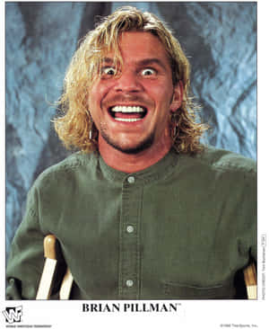 摔角手 Brian Pillman 喺影樓肖像中瞪大雙眼、一頭金髮大笑。