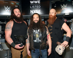 三位WWE摔角手喺NYSE股票上市活動中手持動物面具。