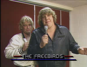 兩位摔角手在後台，一人手持麥克風，帶有文字疊加 The Freebirds