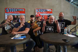 WWE摔角手與粉絲在斯托克頓的簽名活動中手持冠軍腰帶擺姿勢。
