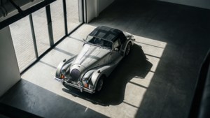 陽光普照的現代混凝土車庫中的銀色經典敞篷車。