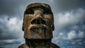 在風暴天空下，帶有烏雲和藍色斑塊的古代石頭摩艾石像。
