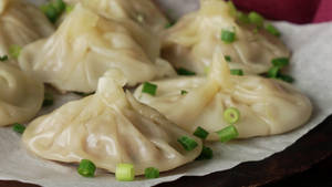 蒸餃子配上蔥花，放在烘焙紙上。