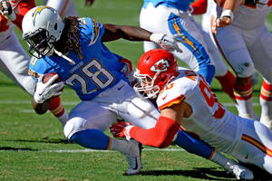 Chargers 球員持球被 Chiefs 防守球員在草地上擒抱