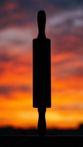 擀麵棍在充滿活力的夕陽天空下的剪影。
