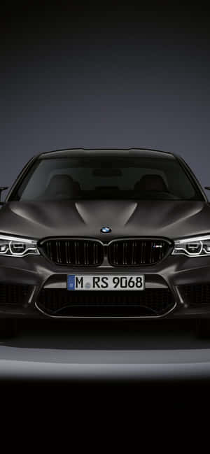 影樓燈光下啞光灰色BMW M5的前視圖。