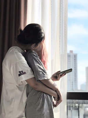 兩人在俯瞰城市的窗邊擁抱。