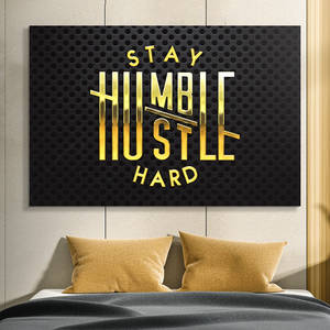 床上方寫有 'Stay Humble Hustle Hard' 的勵志牆飾。