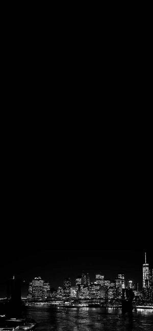 夜間城市天際線，發光的建築物倒映在水中