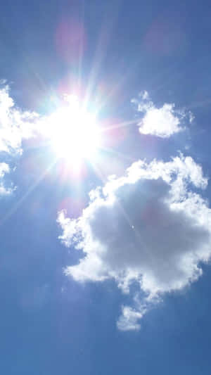 太陽在清澈的藍天中透過散落的雲朵明亮地照耀。