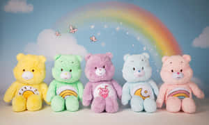 五隻Care Bears毛絨玩具在彩虹下排成一排，伴有蝴蝶。