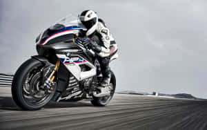 電單車手在賽道上騎著白色、藍色和紅色的BMW HP4 Race比賽。