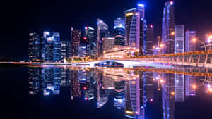 夜間城市天際線，燈火通明的摩天大樓和橋樑倒映在水中。