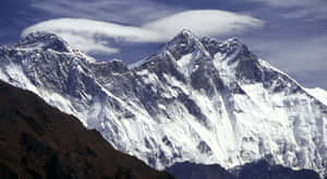 積雪的山脈，岩石斜坡上有透鏡狀雲