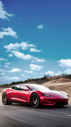 紅色Tesla Roadster在藍天白雲下沙漠公路上飛馳